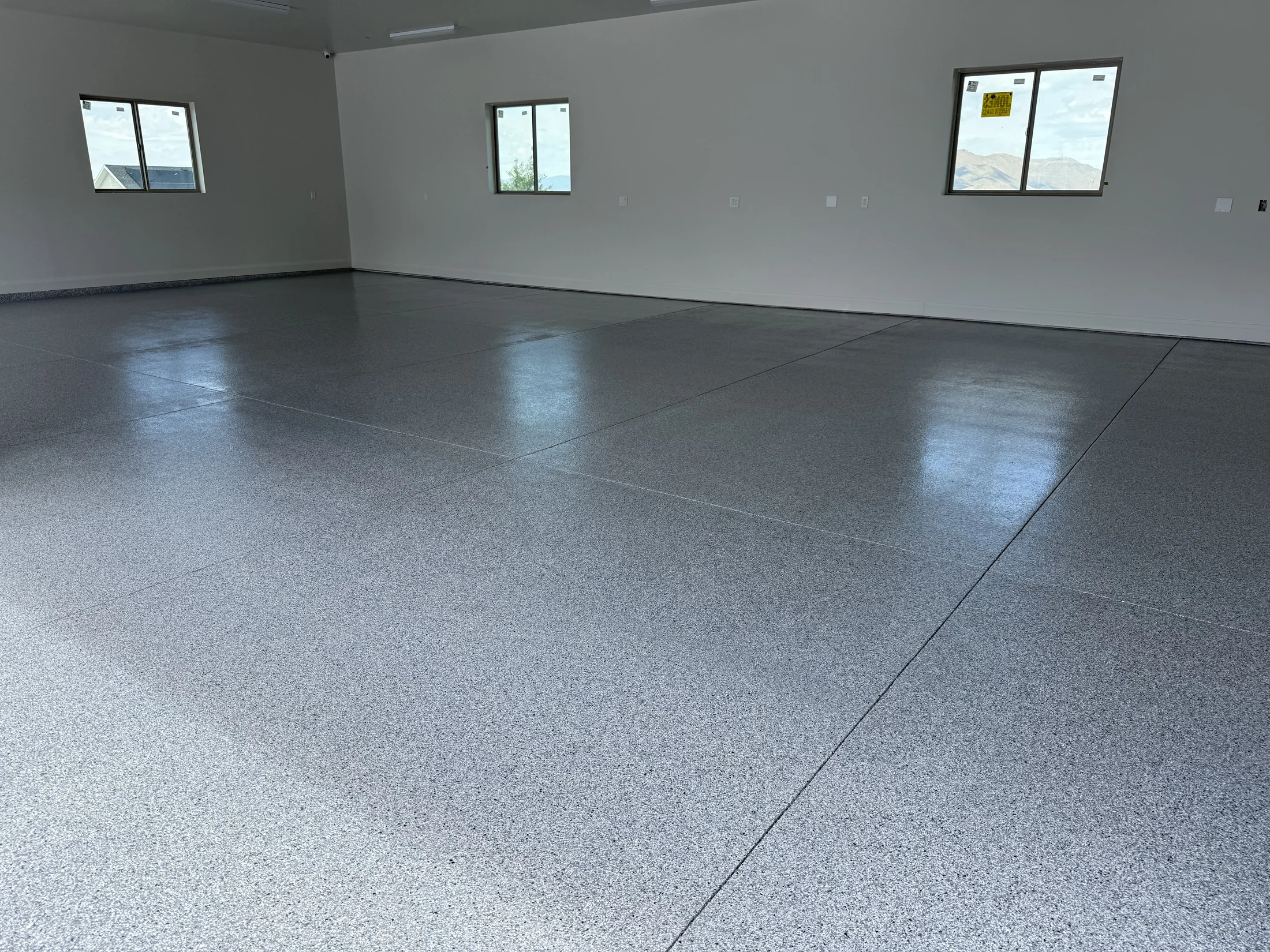 Expansive gray flake epoxy floor in a multi-car garage