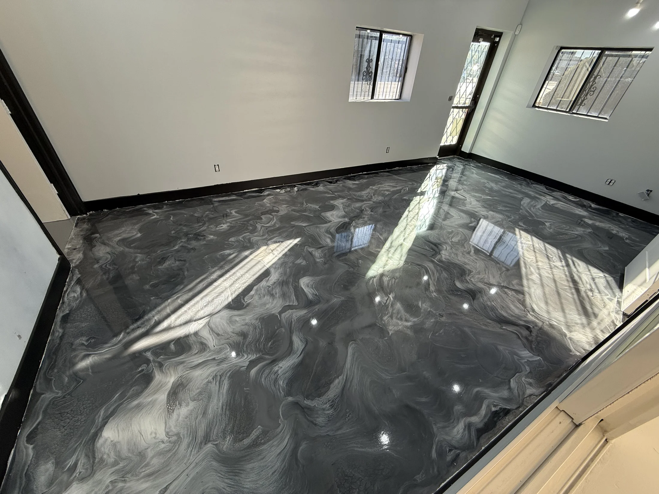 Glossy black and silver metallic epoxy floor in a finished room