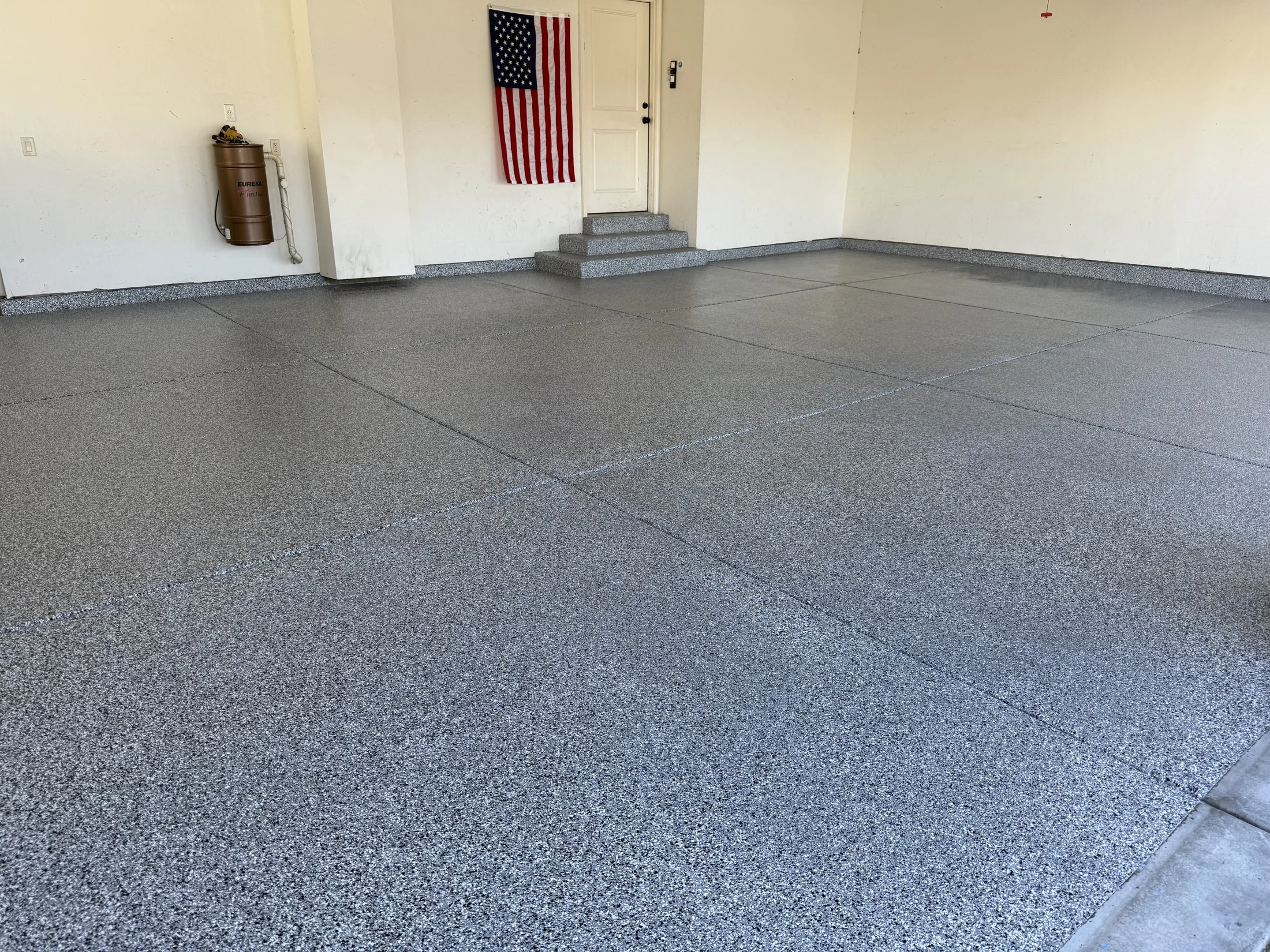 Gray flake epoxy garage floor with coated steps and perimeter