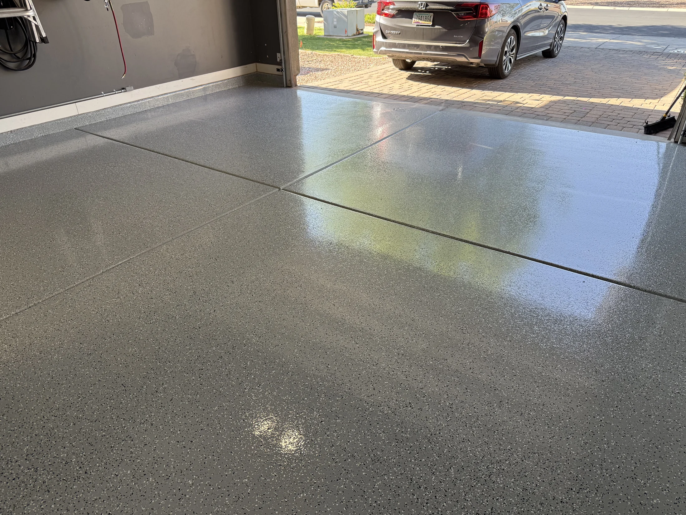 Glossy gray flake epoxy garage floor reflecting natural light