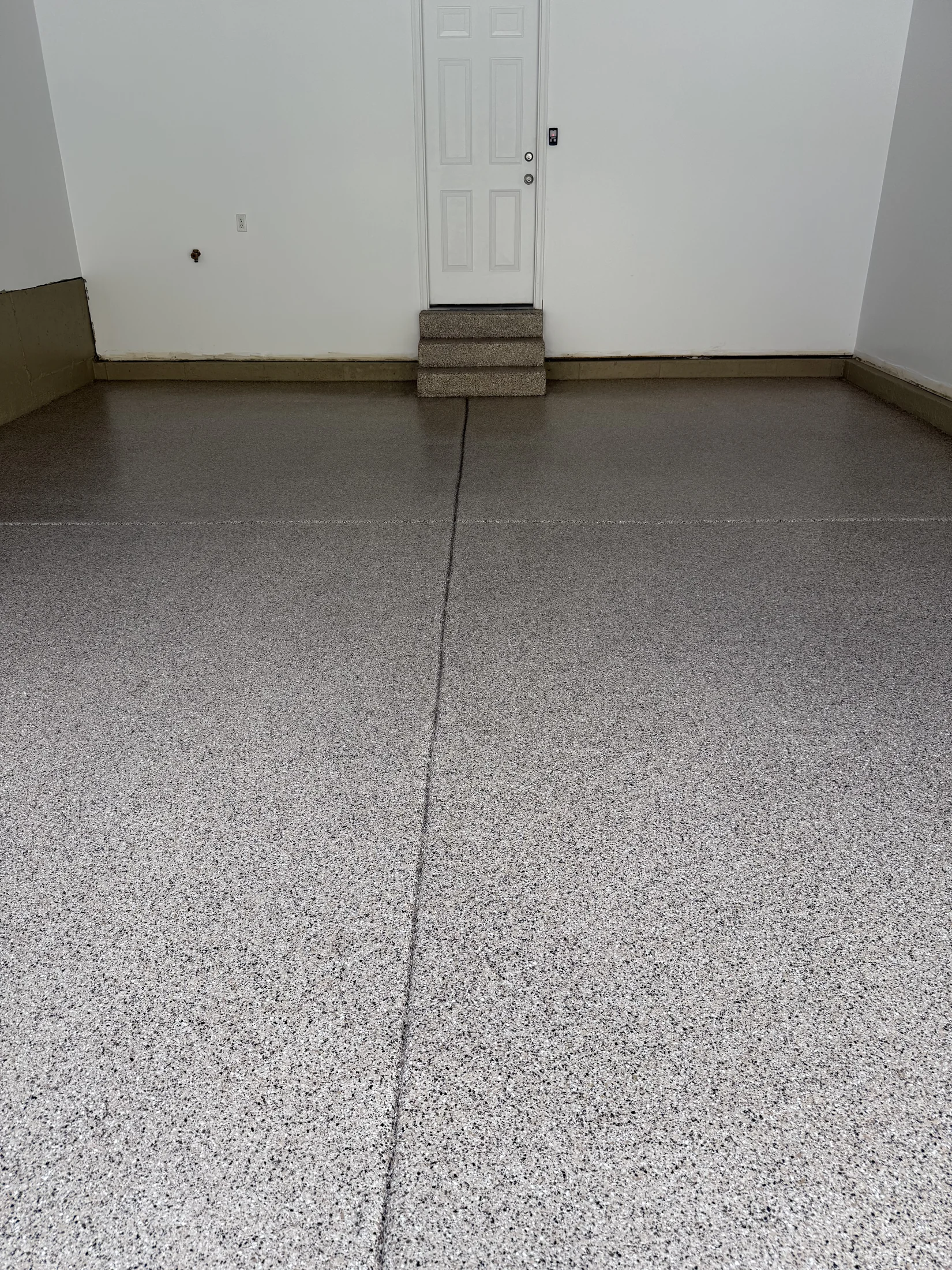 Tan decorative flake garage floor with matching coated entry steps