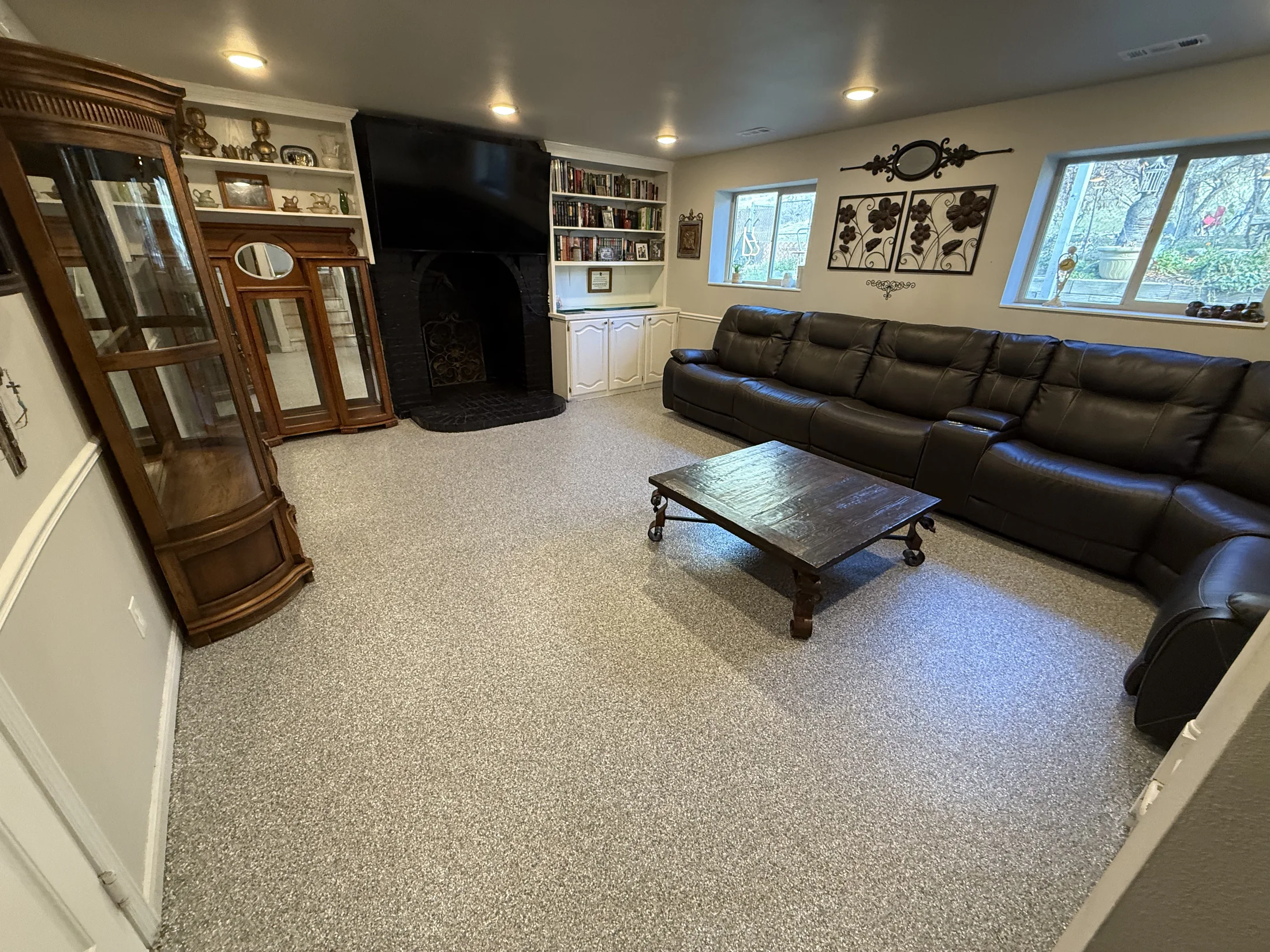 Light gray flake epoxy flooring in a furnished basement living room