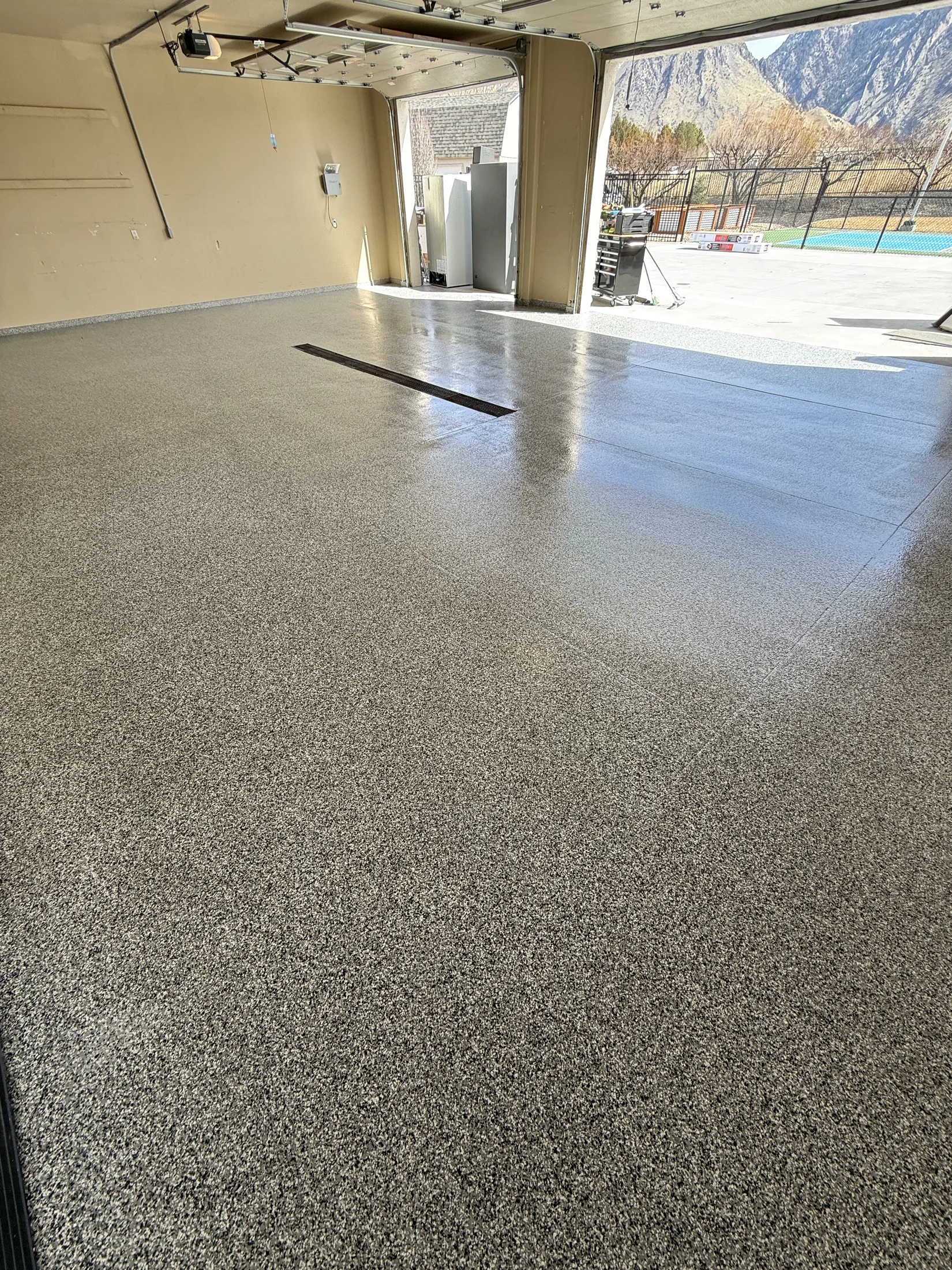 Dense gray and black flake epoxy floor in a single-car garage